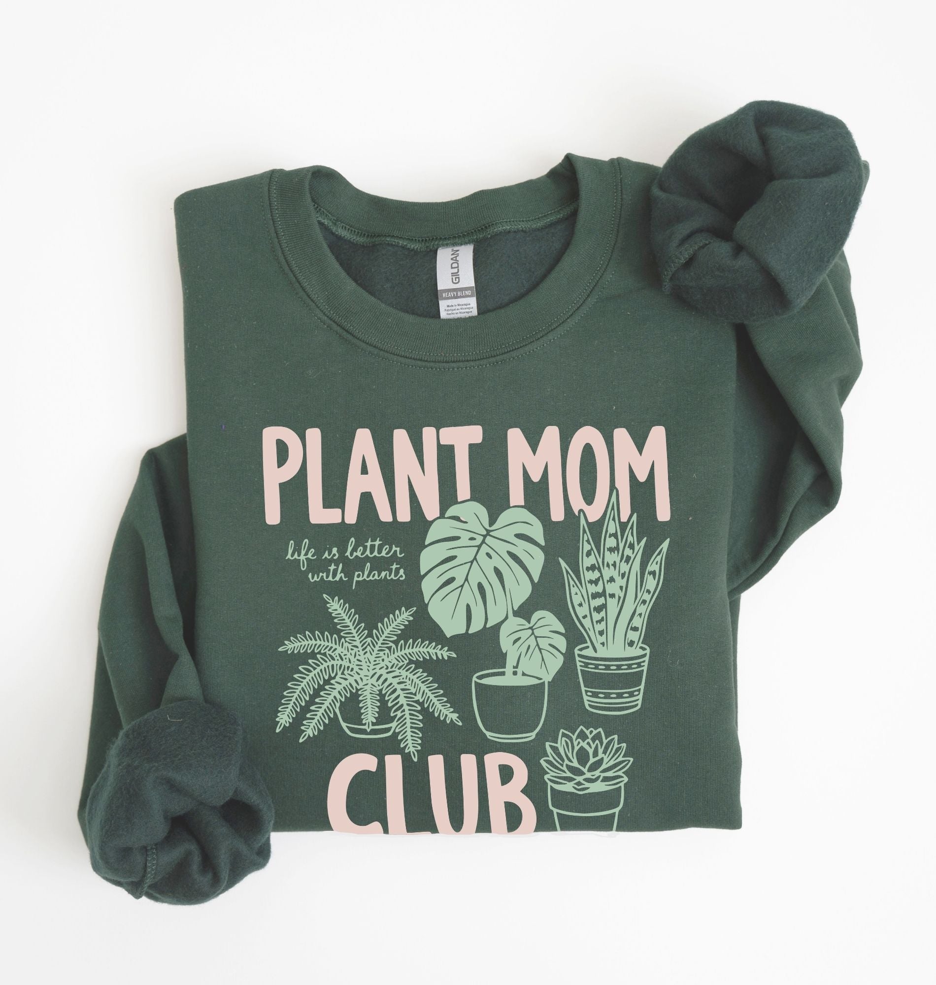 Flat lay of a forest green Plant mom club sweatshirt with houseplant illustrations perfect gift for plant lovers and indoor plant enthusiasts on a white background 