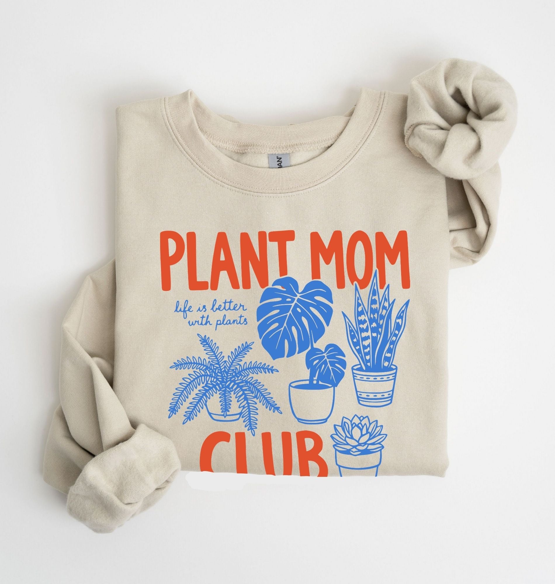 Flat lay of a sand Plant mom club sweatshirt with houseplant illustrations perfect gift for plant lovers and indoor plant enthusiasts on a white background