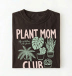 flat lay Plant Mom Club t-shirt with illustrated houseplants, perfect plant lover and gardener gift on a white background