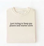 Flat lay of an ivory plants and sourdough starter shirt white funny minimalist plant lover baking t shirt gift on a whiter 