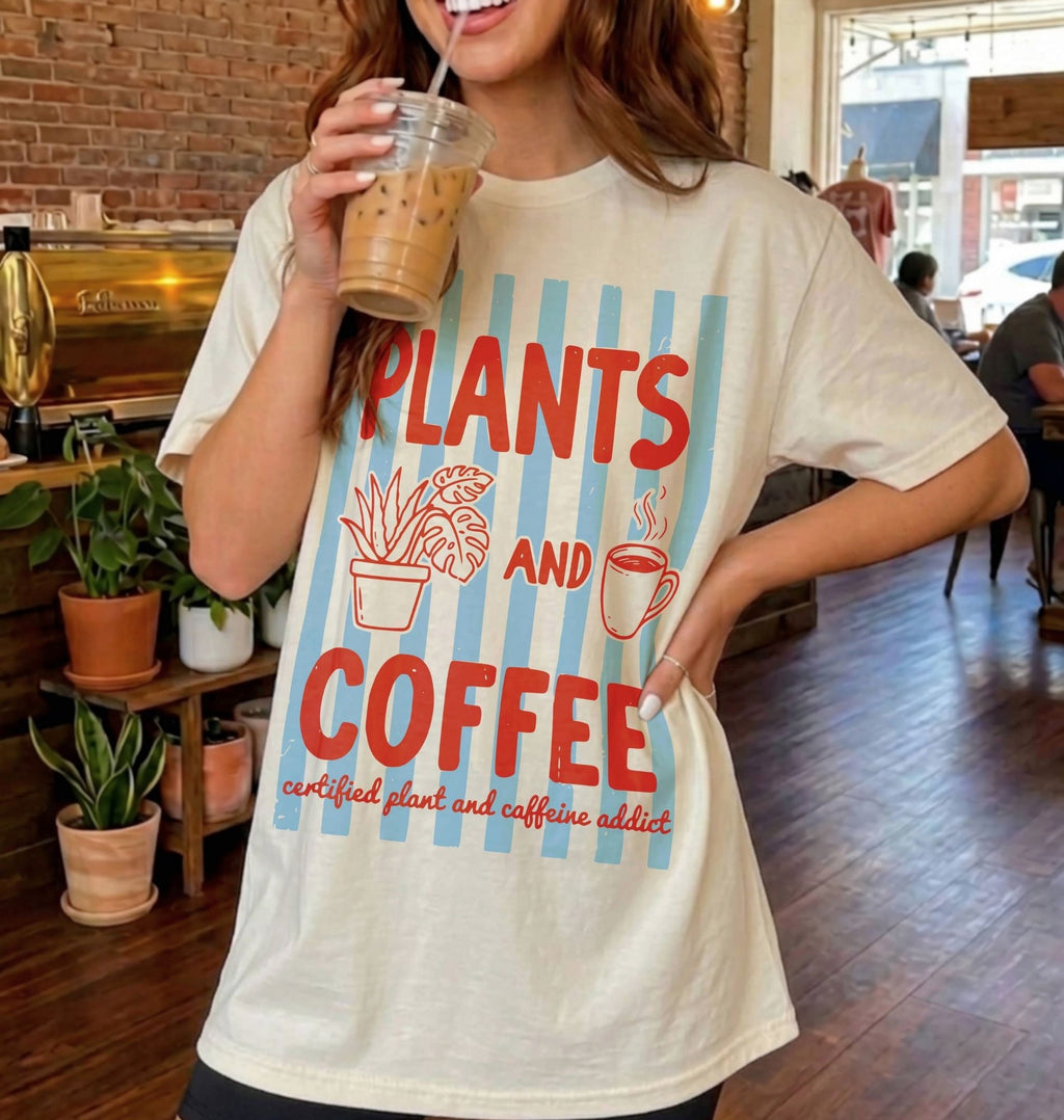 woman standing in a coffee shop with an iced coffee wearing a natural color tshirt that says "plants and coffee"