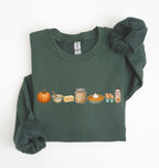 A dark green crewneck sweatshirt with a horizontal graphic print of autumn-themed items including a pumpkin, butter, honey, pie, eggs, and whipped cream. The sweatshirt is styled flat on a white background with rolled cuffs.