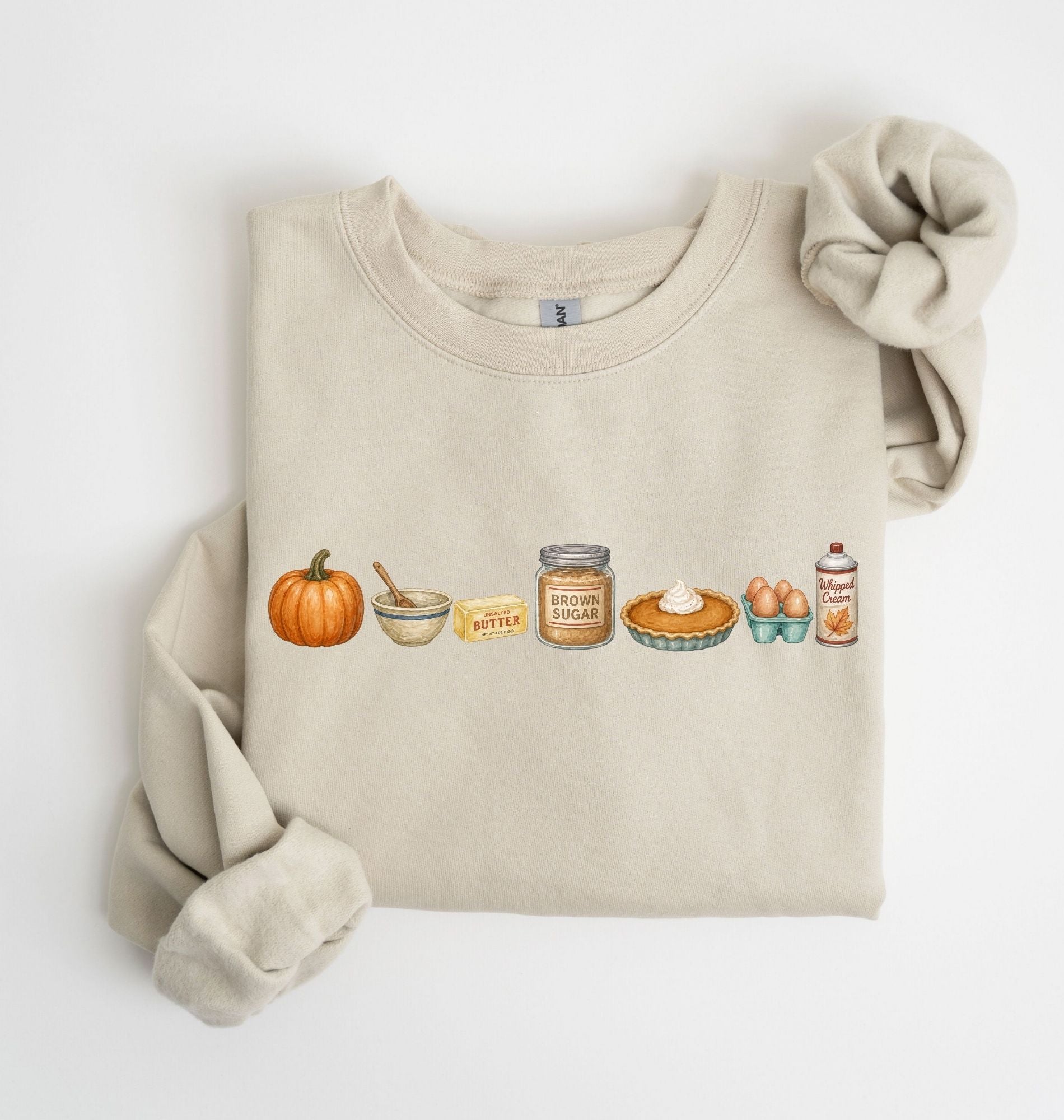 Flat lay of a sand blue Gildan sweatshirt featuring a pumpkin, mixing bowl, butter, brown sugar, pumpkin pie, eggs and whipped cream on a white background 