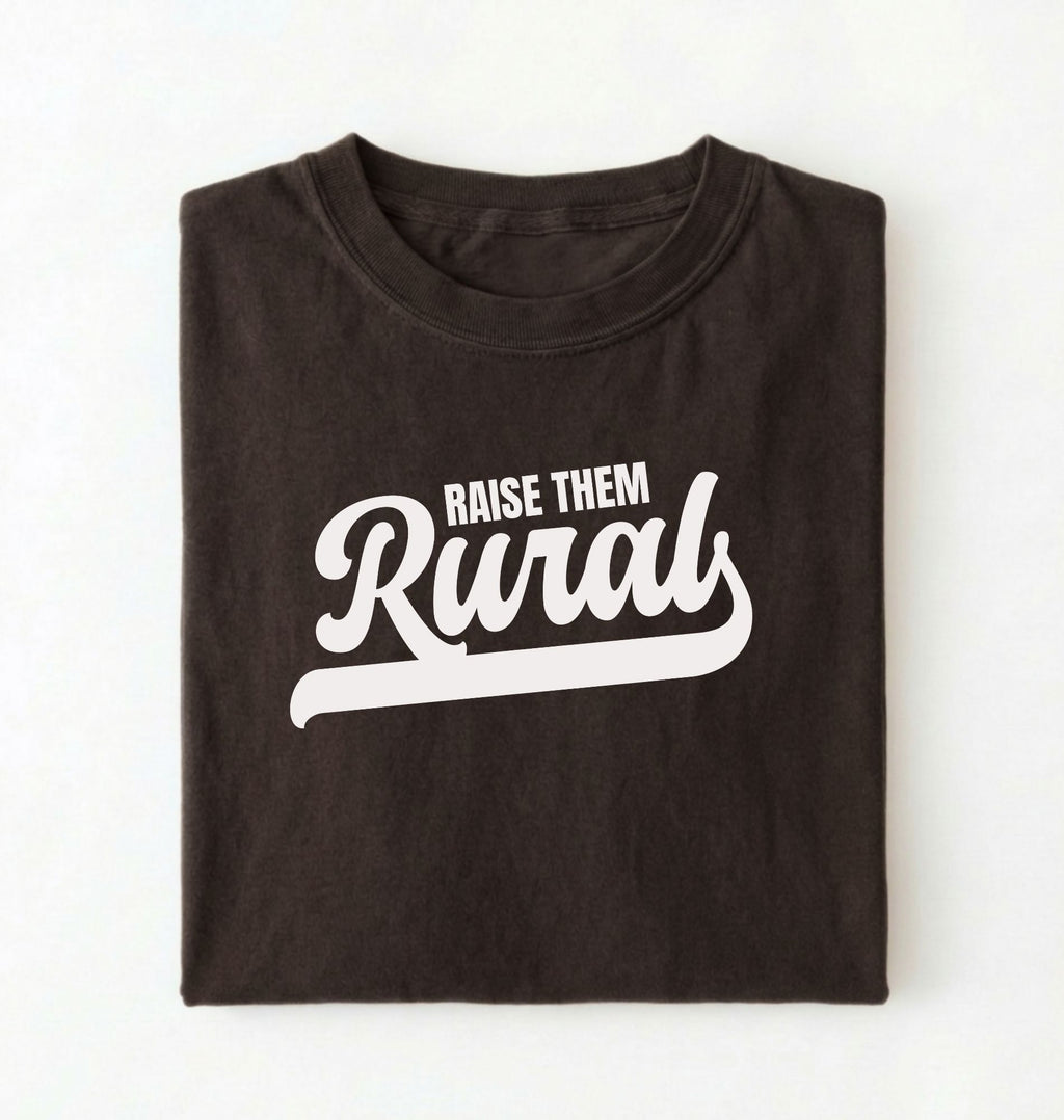 Flat lay of a Raise Them dark chocolate country graphic shirt on pepper tee for farm families and rural lifestyle lovers on a white background 