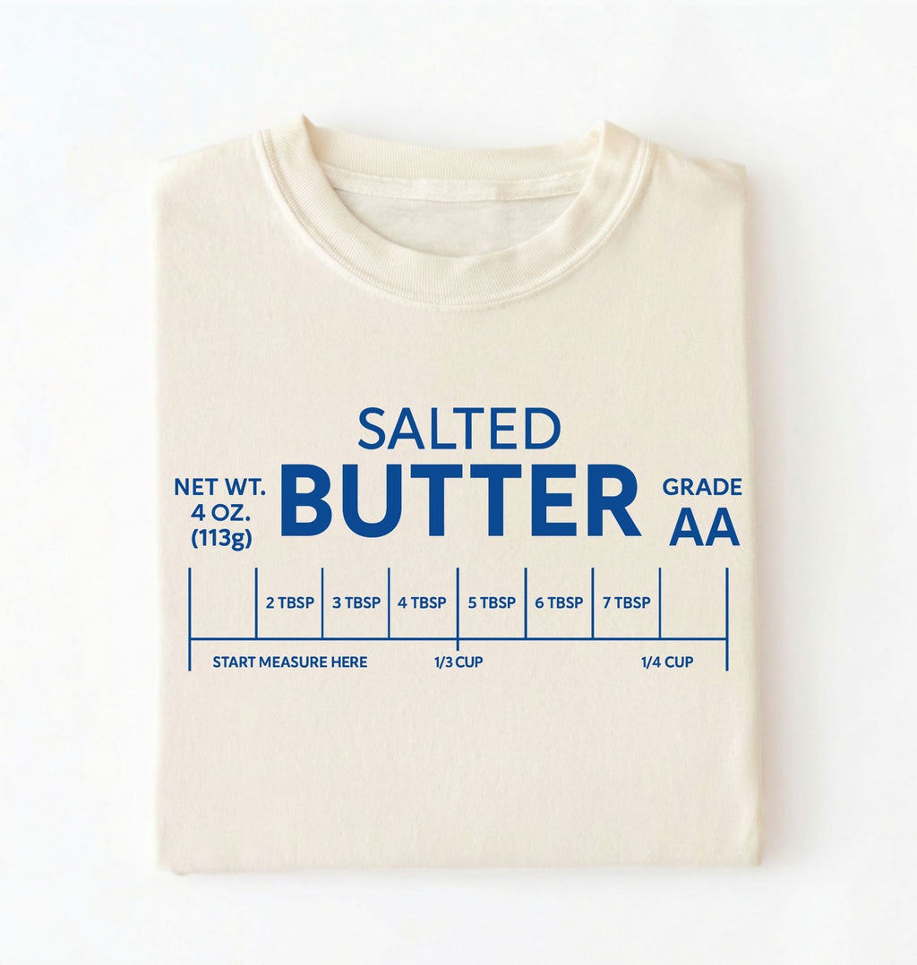 Flat lay of a ivory salted butter shirt funny baking t shirt foodie baker aesthetic gift on a white background 
