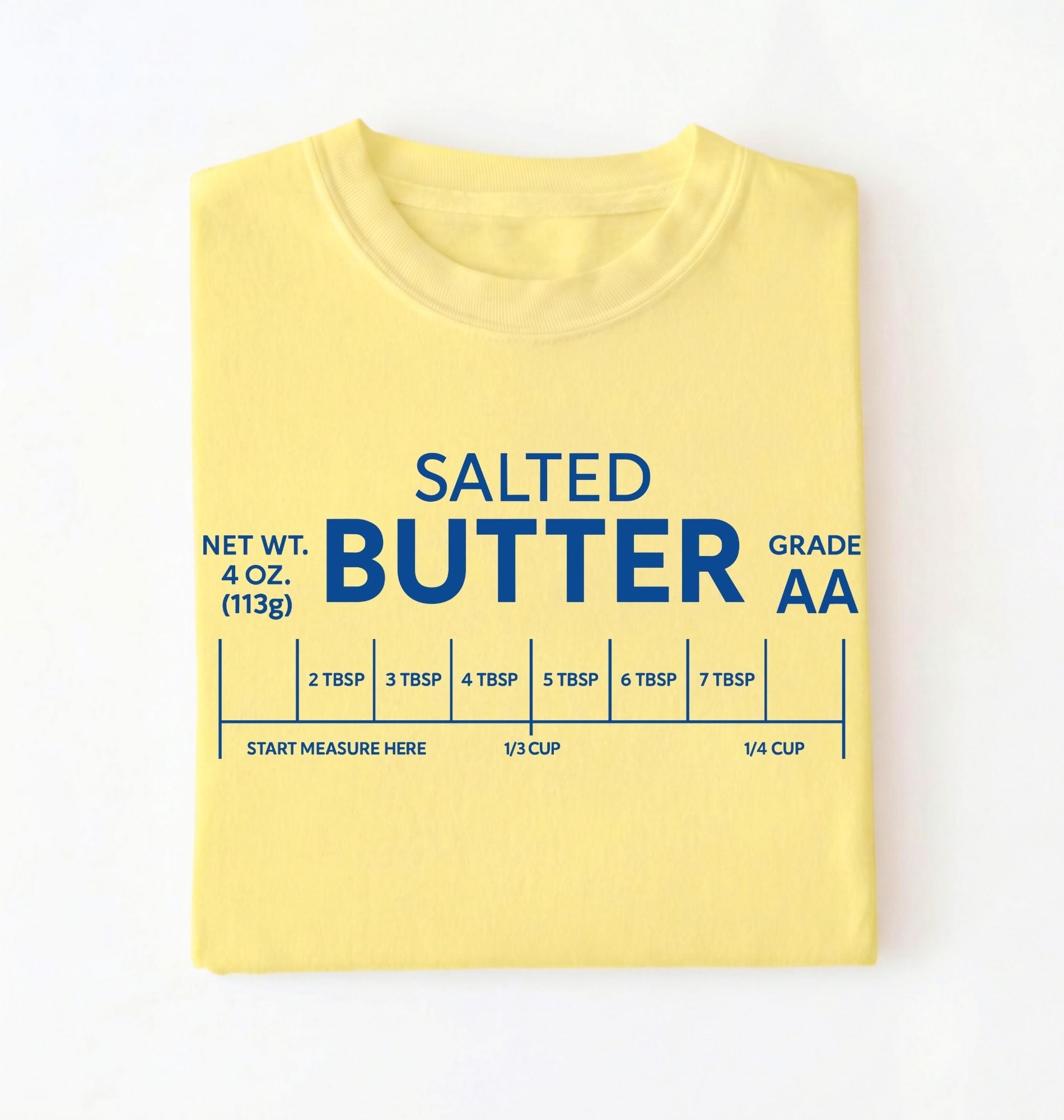 Flat lay of a cornsilk salted butter shirt yellow funny baking t shirt foodie baker aesthetic gift on a white background 