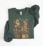 A dark green crewneck sweatshirt featuring a vintage-style Christmas graphic of Santa and Mrs. Claus baking cookies, styled flat on a white background with the cuffs folded up.