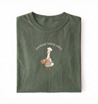 Flat lay of a green Sourdough Baking Addict shirt with baker goose holding artisan bread for sourdough enthusiasts on a white background 