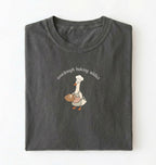 Flat lay of a dark grey Sourdough Baking Addict shirt with baker goose holding artisan bread for sourdough enthusiasts on a white background 