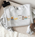 Gray sweatshirt with food-themed illustrations on a textured surface