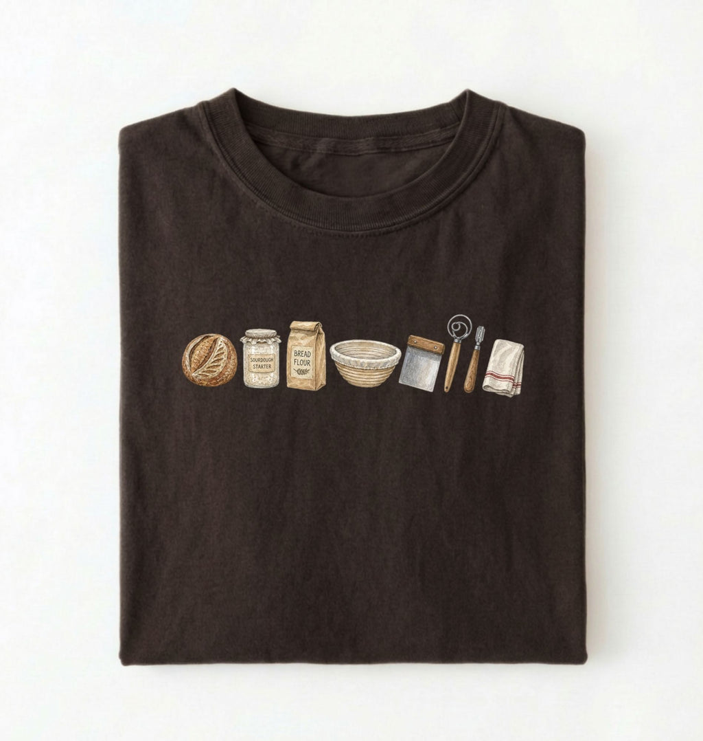 Flat lay of a brown sourdough baking essentials shirt with starter flour dough bowl and bread making tools on a white background 
