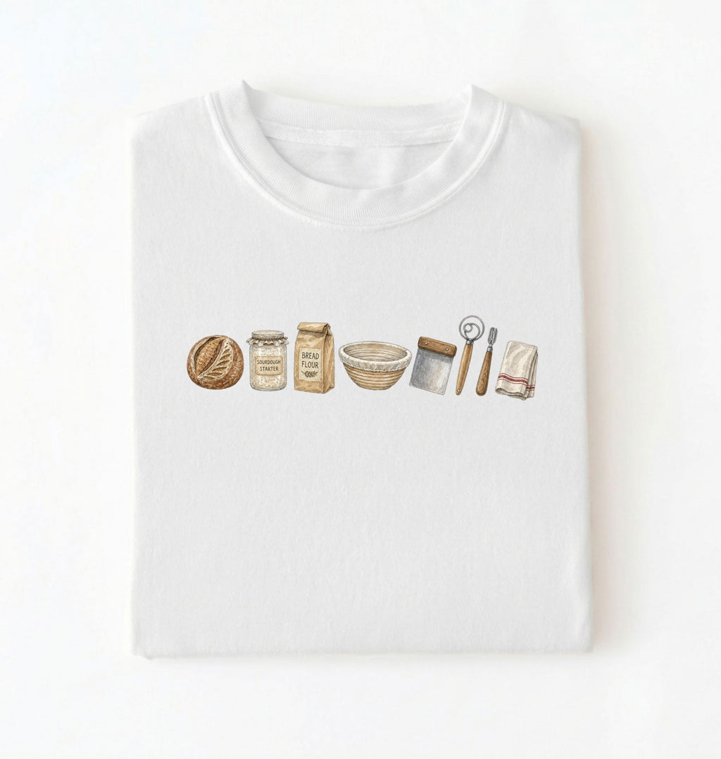 Flat lay of a white sourdough baking essentials shirt with starter flour dough bowl and bread making tools on a white background 