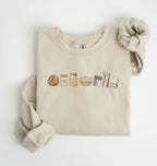 Flat lay of a sand sourdough baking essentials sweatshirt with bread starter flour bowl and baking tools on a white background 