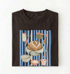 Flat lay of a brown Sourdough baking tools shirt featuring artisan bread, starter jar, banneton, and baking supplies on a white background 
