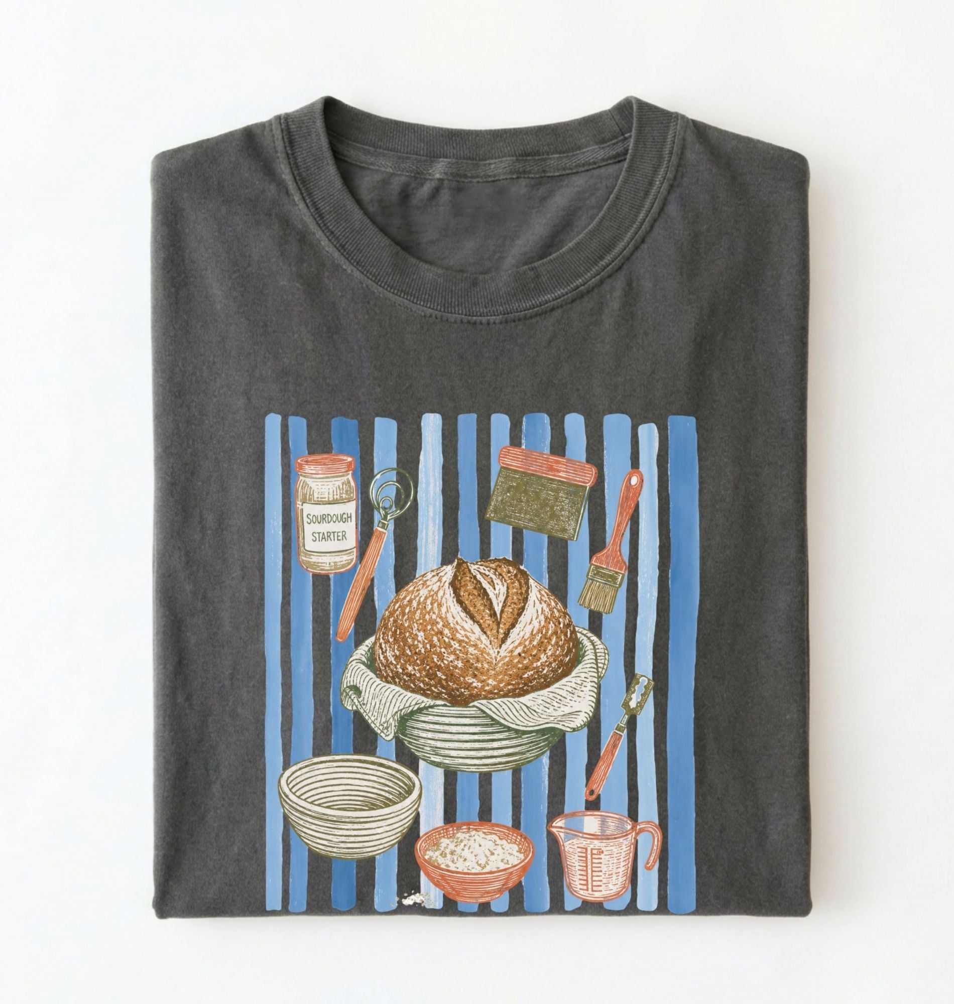 Flat lay of a charcoal Sourdough baking tools shirt featuring artisan bread, starter jar, banneton, and baking supplies on a white background 