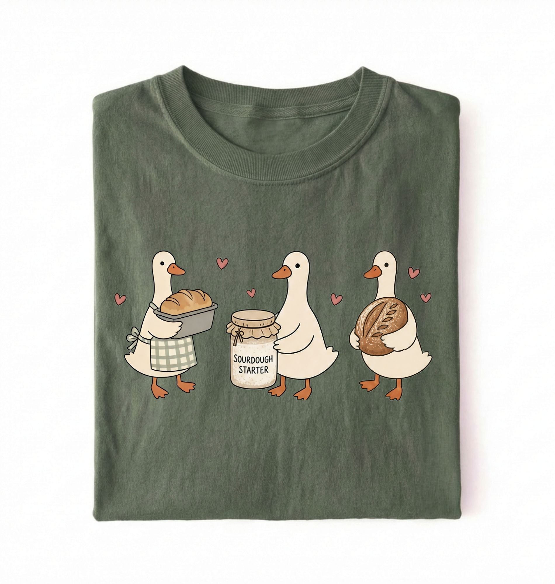 Flat lay of a green Cute sourdough ducks graphic shirt featuring bread and sourdough starter design for bakers on a white background