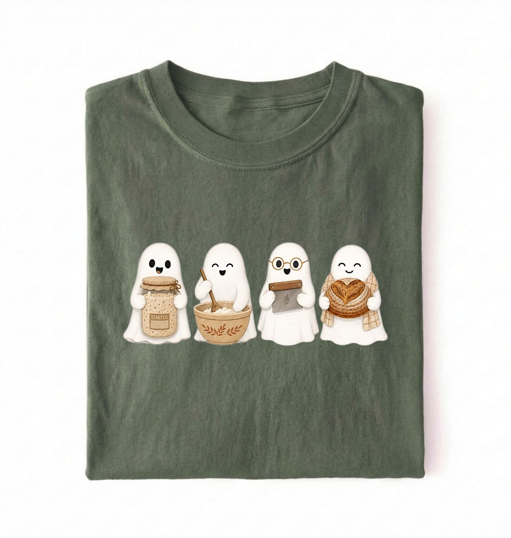 Flat lay of a Moss green sourdough shirt featuring four cute baking ghosts with a starter jar, mixing bowl, bench scraper and bread loaf on a white background 