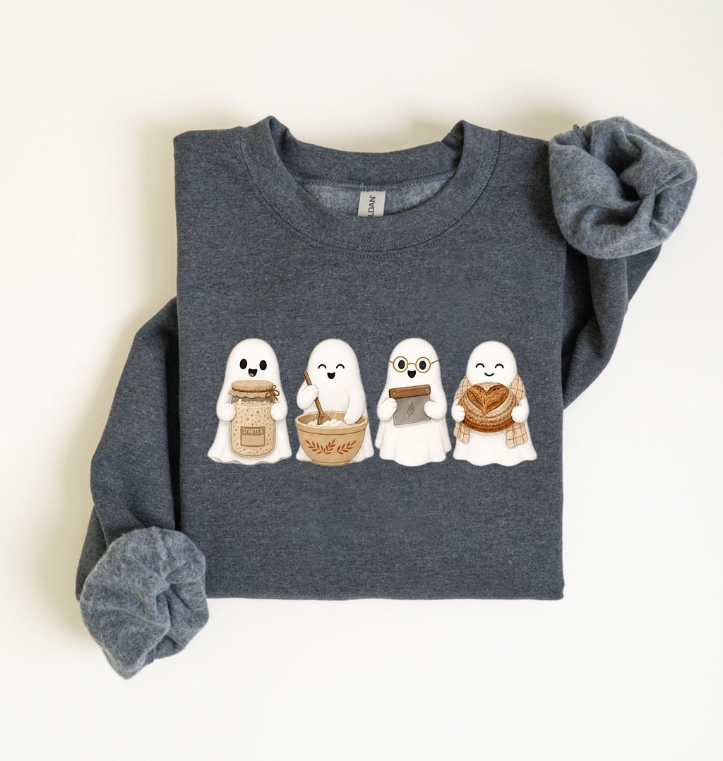 Flat lay of an dark heather sourdough sweatshirt featuring four cute baking ghosts with a starter jar, mixing bowl, bench scraper and bread loaf on a white background 