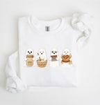 Flat lay of a white sourdough sweatshirt featuring four cute baking ghosts with a starter jar, mixing bowl, bench scraper and bread loaf on a white background 