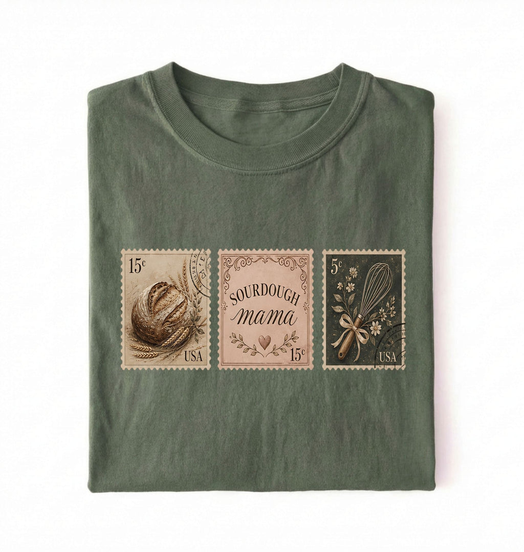 Flat lay of a moss sourdough mama shirt brown vintage baking stamps t shirt bread lover gift cozy kitchen design on a white background
