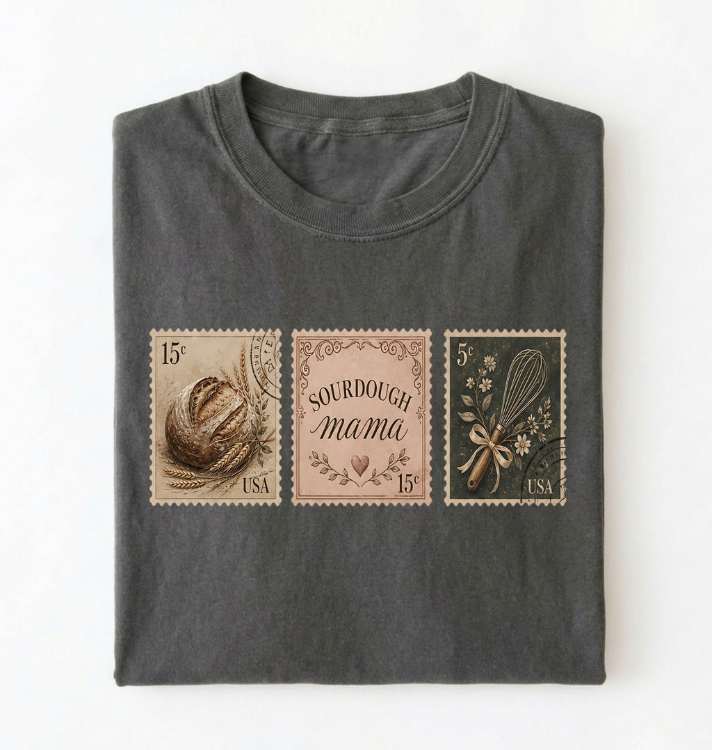Flat lay of a pepper sourdough mama shirt brown vintage baking stamps t shirt bread lover gift cozy kitchen design on a white background