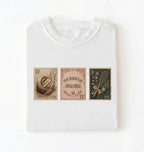 Flat lay of a white sourdough mama shirt brown vintage baking stamps t shirt bread lover gift cozy kitchen design on a white background