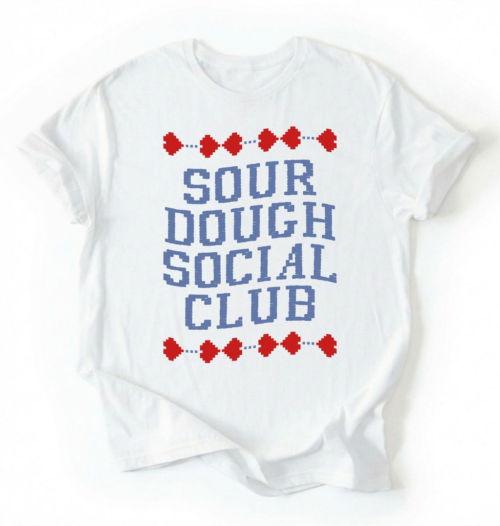 Flat lay of a white sourdough social club shirt cream funny baking t shirt bread lover gift cottagecore aesthetic on a white background 