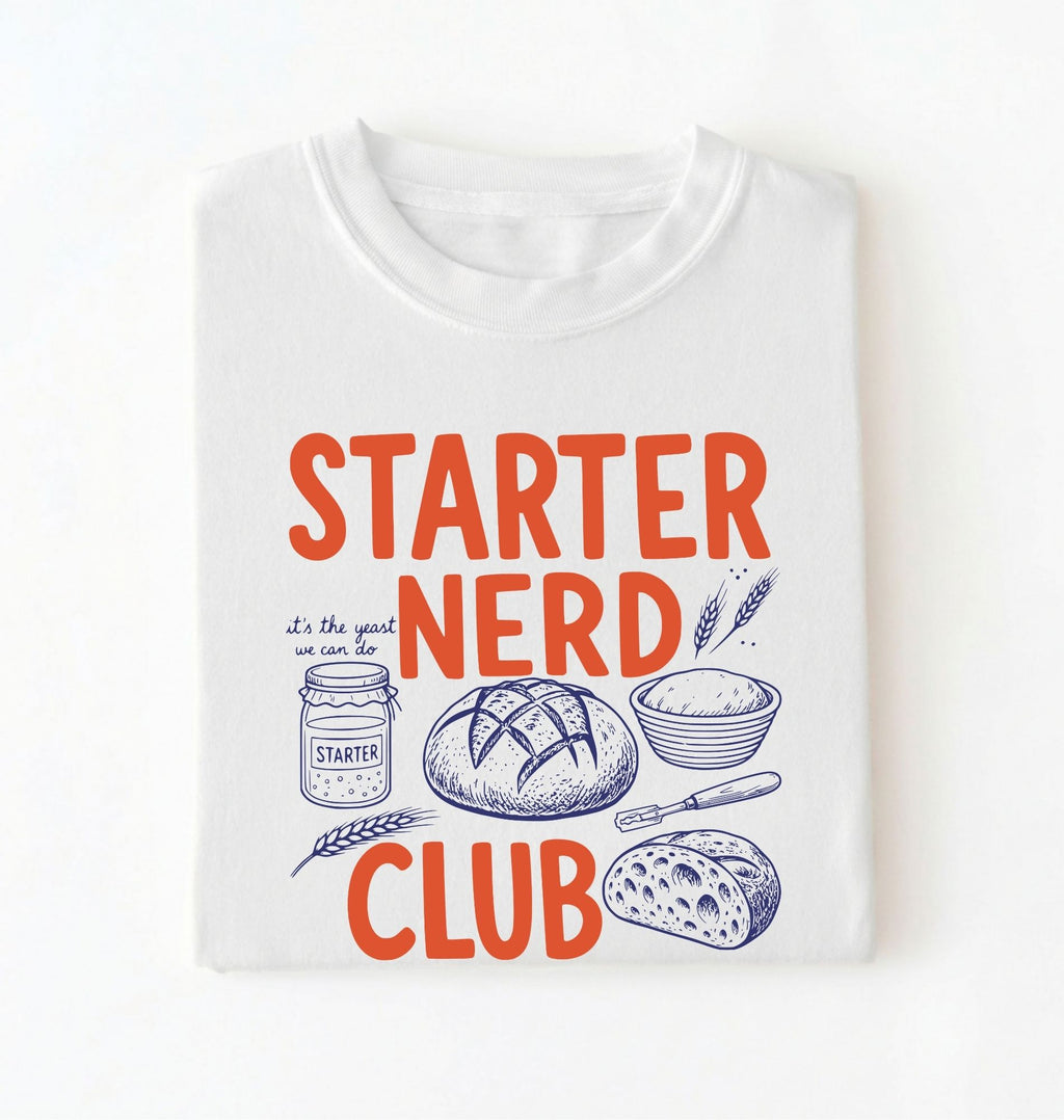 Flat lay of a white starter nerd club shirt with sourdough starter jar bread and baking illustrations funny baker gift on a white background 