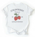 Flat lay of a Vintage strawberry festival graphic shirt with locally sourced design on white tee on a white background 