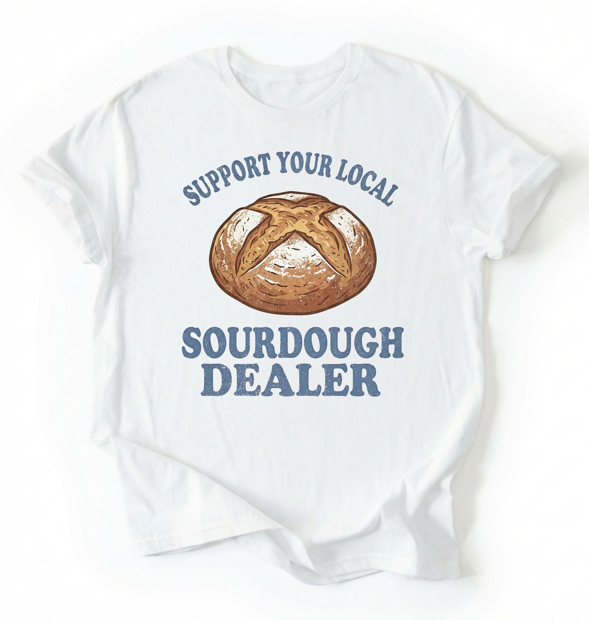 Flat lay of a Support Your Local Sourdough Dealer shirt with artisan sourdough bread graphic on white tee on a white background 