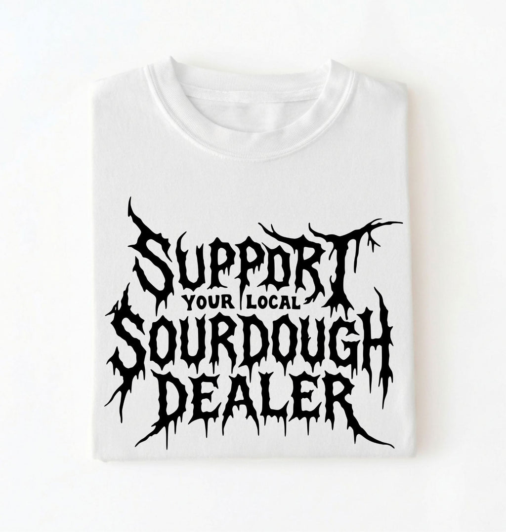 A white short-sleeve crewneck t-shirt with a black graphic print that reads 'SUPPORT YOUR LOCAL SOURDOUGH DEALER' in a stylized, jagged font, displayed flat against a white background.