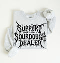 A light heather gray sweatshirt with a black graphic text reading 'SUPPORT YOUR LOCAL SOURDOUGH DEALER' in a stylized font, laid flat on a light cream background.