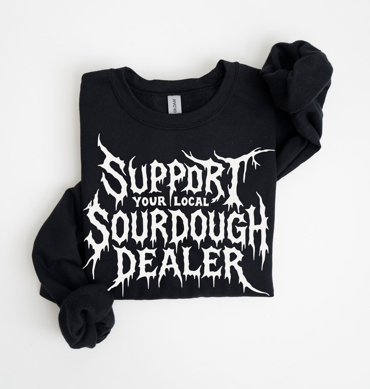 A black long-sleeve sweatshirt with rolled-up sleeves, featuring a white graphic text print that reads 'SUPPORT YOUR LOCAL SOURDOUGH DEALER' in a jagged, horror-style font. The sweatshirt is laid flat on a clean white background.