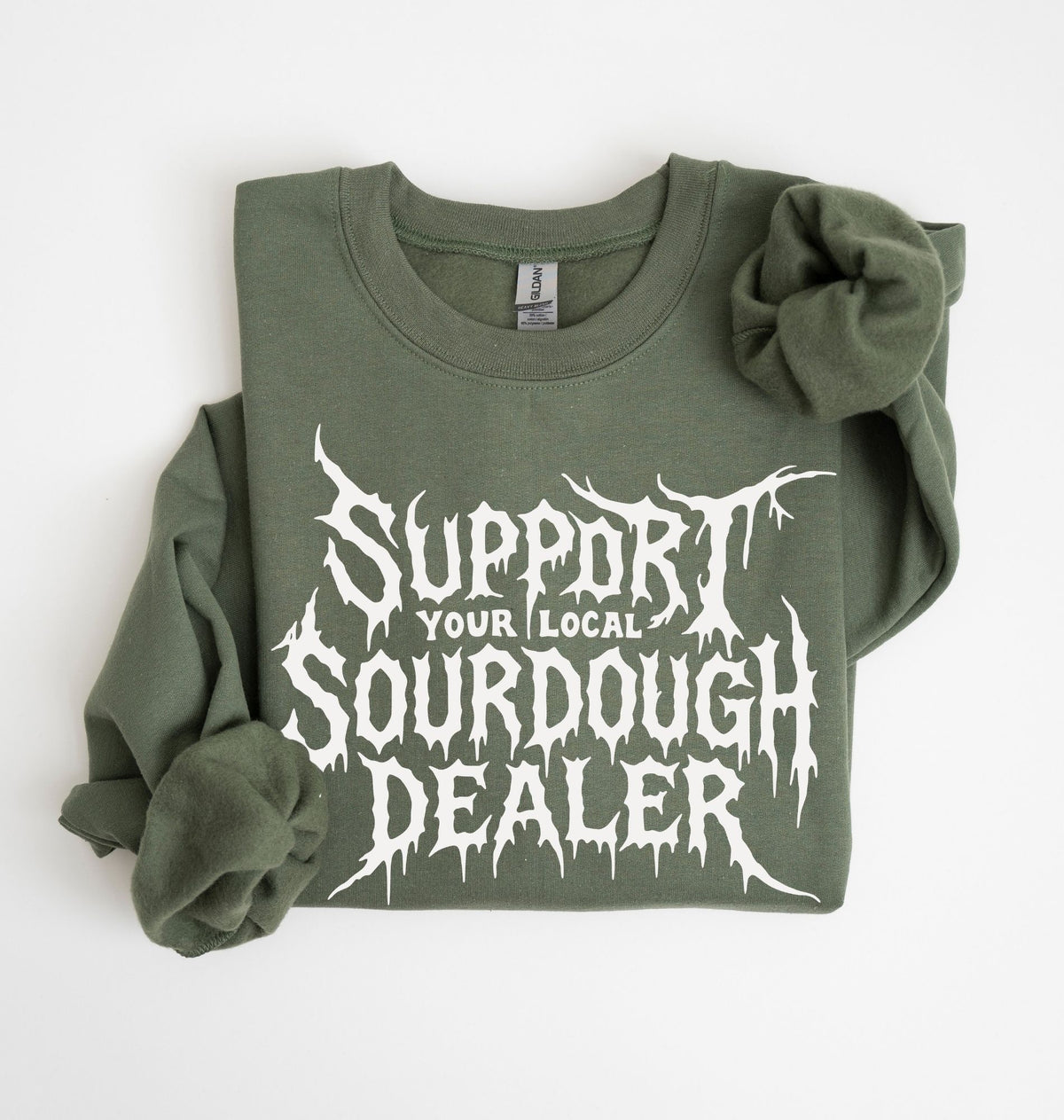 An olive green crewneck sweatshirt with rolled-up sleeves, featuring a white graphic print that reads 'SUPPORT YOUR LOCAL SOURDOUGH DEALER' in a stylized font, laid flat on a white background.