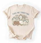 Flat lay of an ivory take me thrifting shirt cream vintage thrift store t shirt cottagecore antique gift on a white background 