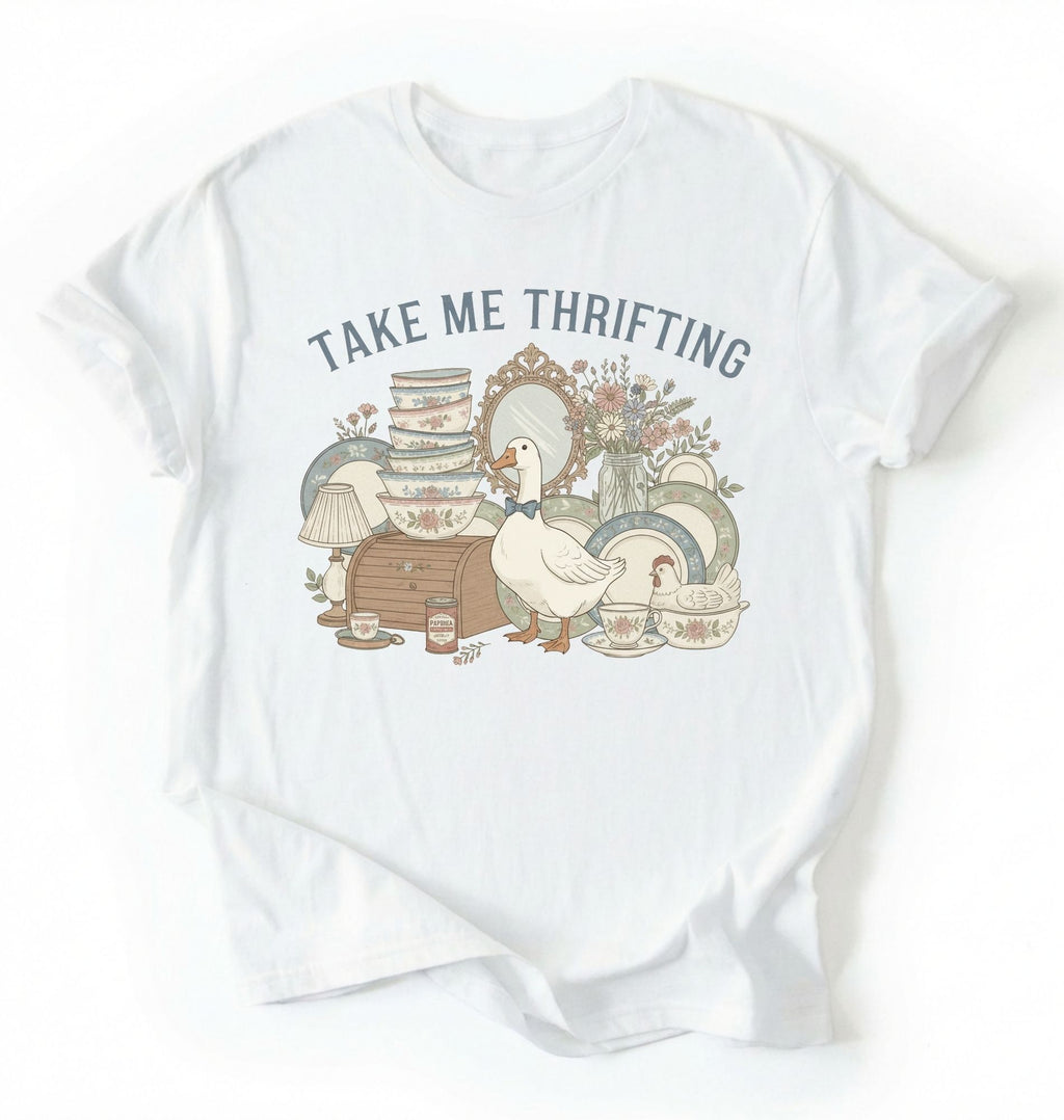 Flat lay of an white take me thrifting shirt cream vintage thrift store t shirt cottagecore antique gift on a white background 