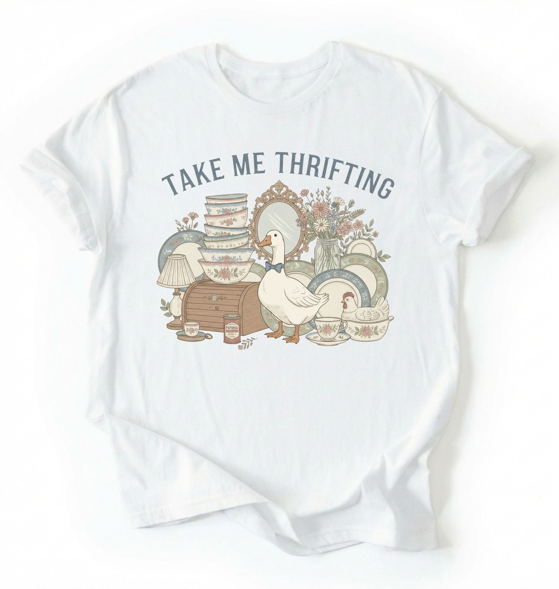 Flat lay of an white take me thrifting shirt cream vintage thrift store t shirt cottagecore antique gift on a white background 
