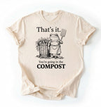 Flat lay of a Natural t-shirt featuring an illustrated frog with text reading “That’s it you’re going in the compost frog t-shirt” on a white background