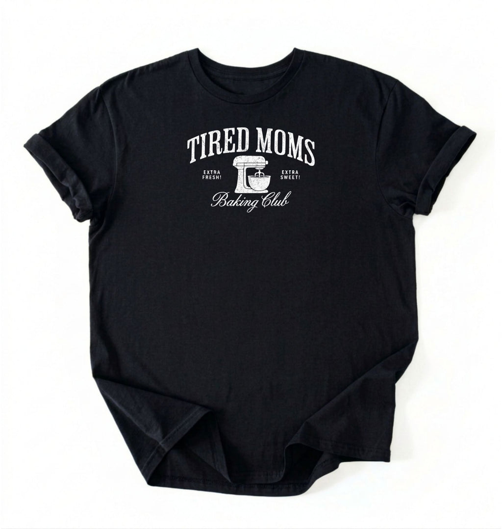 Flat lay of a black Tired Moms Baking Club graphic shirt with stand mixer design for baking moms on a white background 