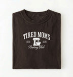 Flat lay of a brown Tired Moms Baking Club graphic shirt with stand mixer design for baking moms on a white background 