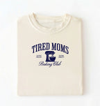 Flat lay of a ivory Tired Moms Baking Club graphic shirt with stand mixer design for baking moms on a white background 
