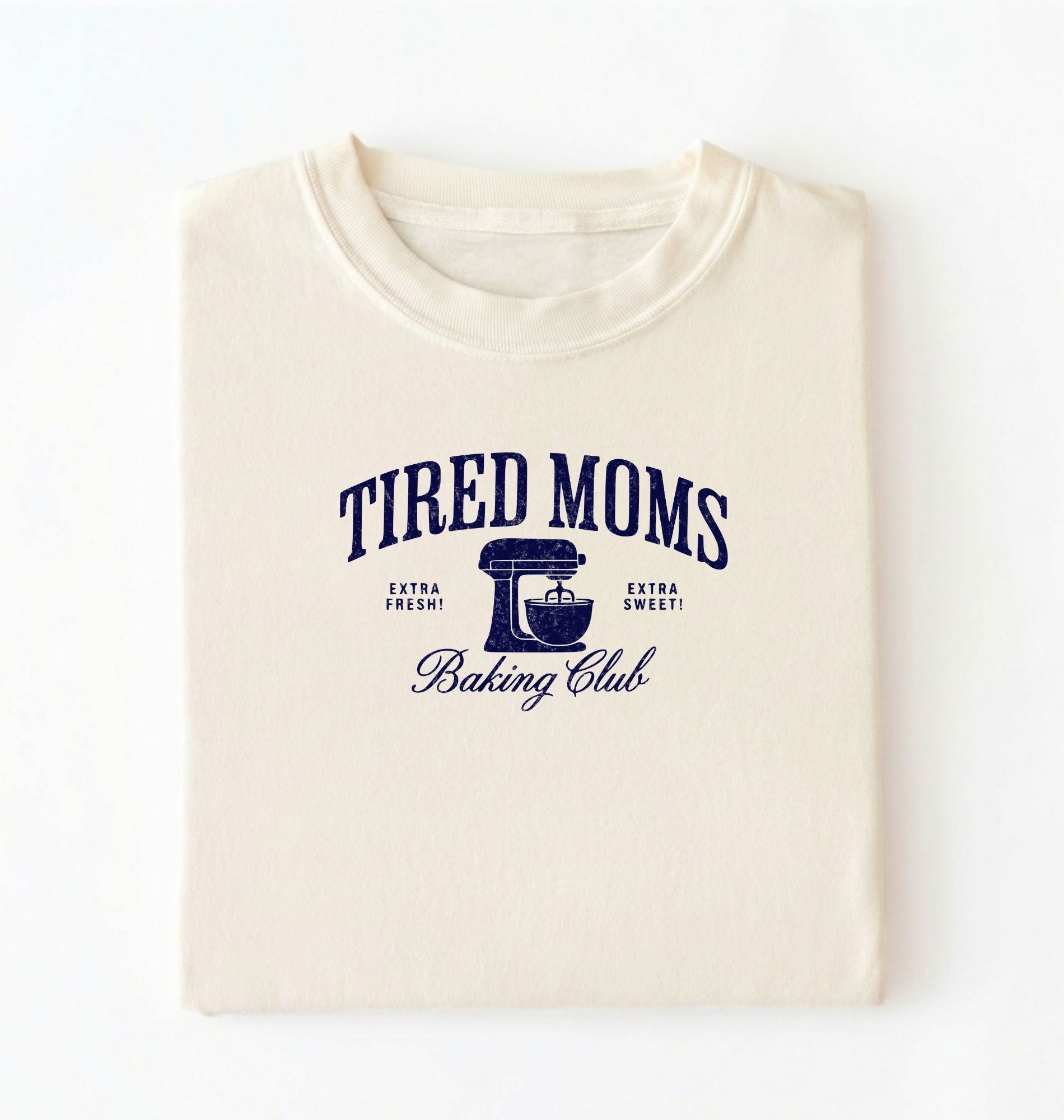 Flat lay of a ivory Tired Moms Baking Club graphic shirt with stand mixer design for baking moms on a white background 
