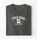 Flat lay of a grey Tired Moms Baking Club graphic shirt with stand mixer design for baking moms on a white background 