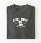 Flat lay of a grey Tired Moms Baking Club graphic shirt with stand mixer design for baking moms on a white background 