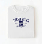 Flat lay of a white Tired Moms Baking Club graphic shirt with stand mixer design for baking moms on a white background 