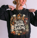 woman wearing a black sweatshirt with christmas, fall and baking icons that says "tis the season for baking"