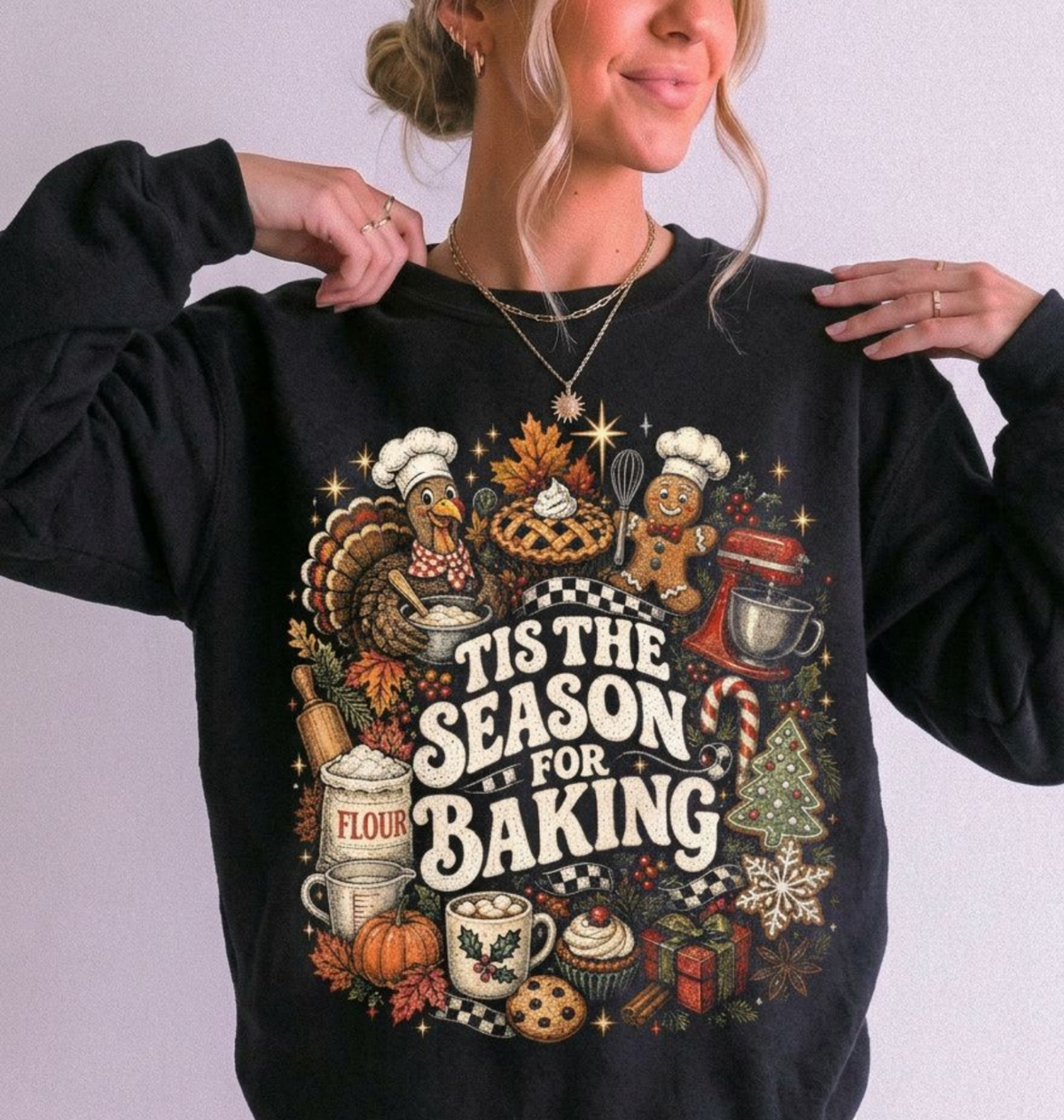 woman wearing a black sweatshirt with christmas, fall and baking icons that says "tis the season for baking"