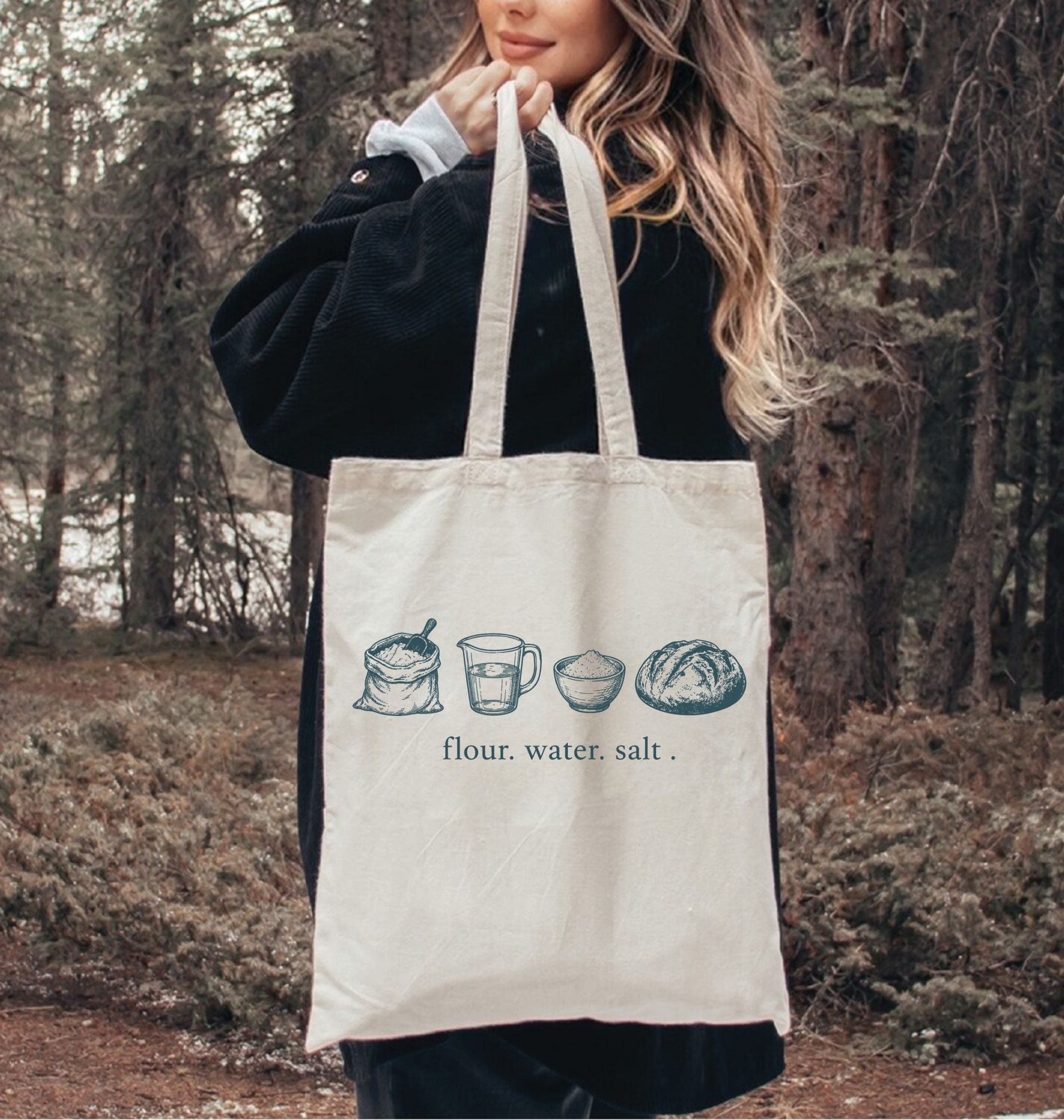 Person holding a tote bag with bread-making ingredients illustration in a forest setting