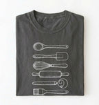 Flat ay of a Vintage baking tools shirt with whisk rolling pin and spatula illustrations on pepper tee on a white background 