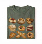A folded dark olive green t-shirt featuring a graphic print of various illustrated pastries, cakes, and breads, displayed against a plain white background.